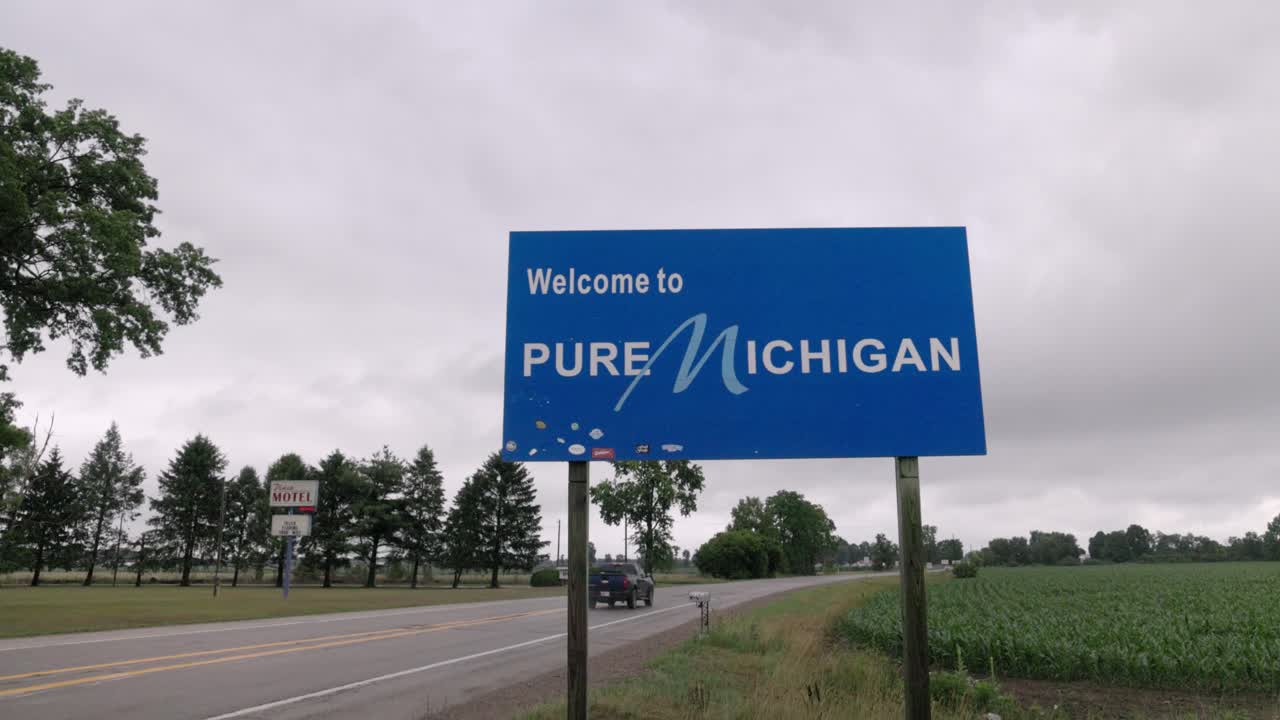 para dar la bienvenida a puro signo de michigan en la línea estatal de michigan e indiana con video gimbal caminando hacia adelante