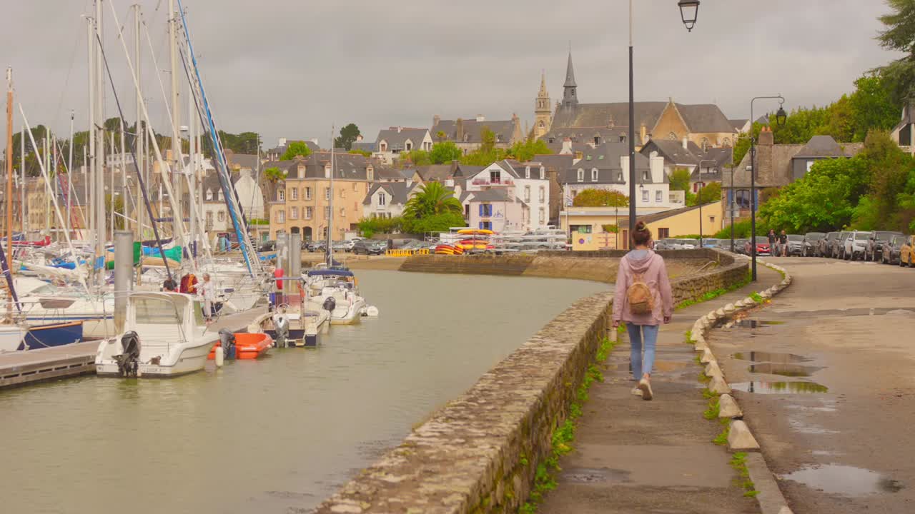 Scenic Promenade At Port Of Saint-Goustan In Brittany, France, With Docked Sailboats And Historic Buildings On Cloudy Day. wide shot