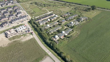 Aerial-orbit-of-earthship-district-near-traditional-town