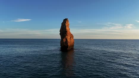 beach to sea stack flyby. steady proximity drone shot.