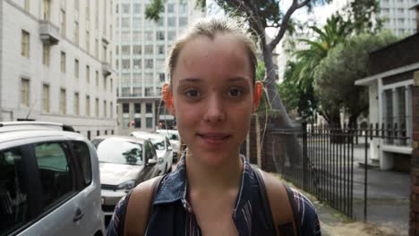 vista frontal de una chica caucásica en la calle mirando a la cámara