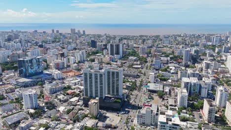 Experience-the-vibrant-urban-life-of-Santo-Domingo,-Dominican-Republic,-with-dynamic-aerial-footage-showcasing-bustling-streets-and-towering-skyscrapers