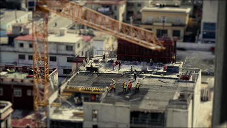 construction workers wearing high visual clothing and laying steel reinforcement preparing for the concrete to be poured. tilt and shift, stop motion, miniature world.
