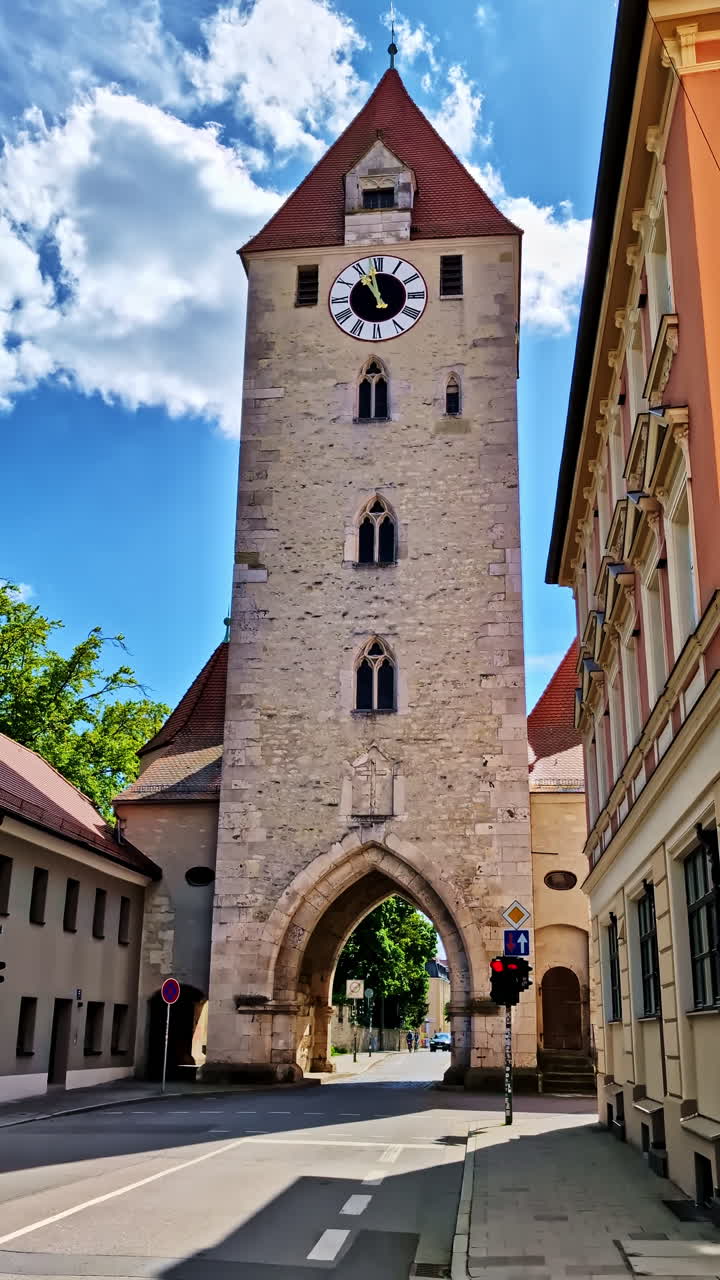 Ostentor Gate Tower and Historic Street in Regensburg Under Blue Sky