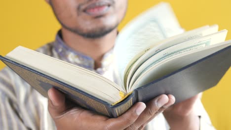 hombre musulmán con la mano sosteniendo el libro sagrado corán