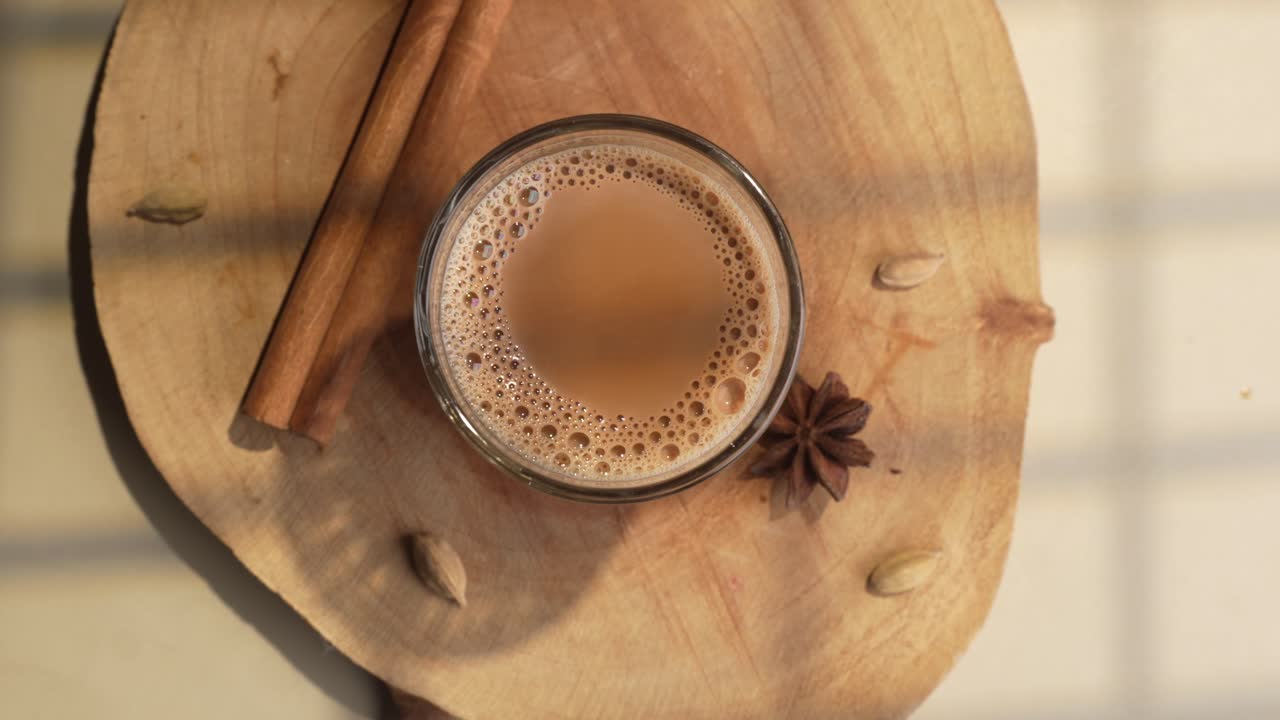 Chai indiano servito in tazze di vetro, preparato in una teiera di metallo con masala aromatici