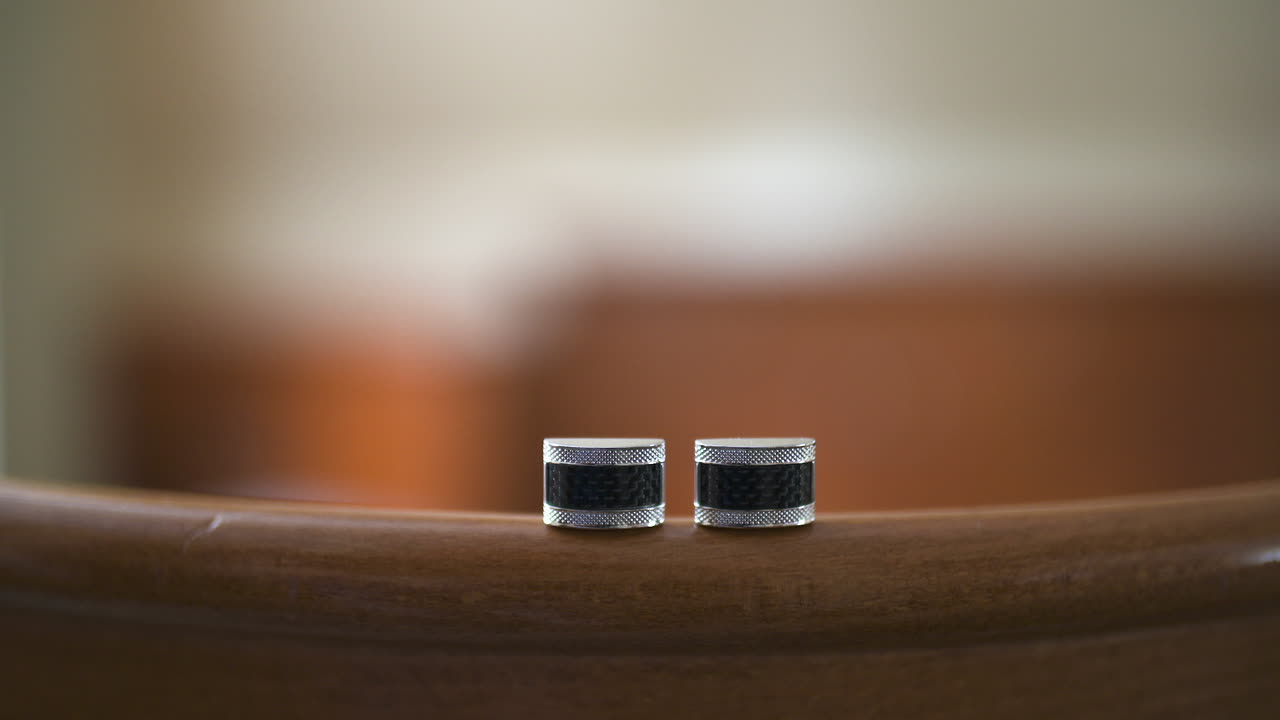 Pair of Elegant Silver and Black Cufflinks on Wooden Surface