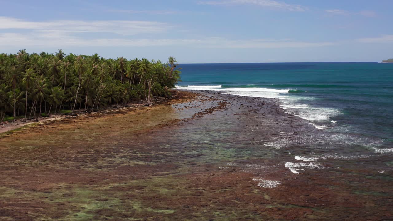 vista della gru verso il basso del drone della marea che si riversa sulla costa della giungla indonesiana