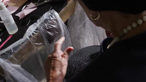 mixed race woman working at a hat factory