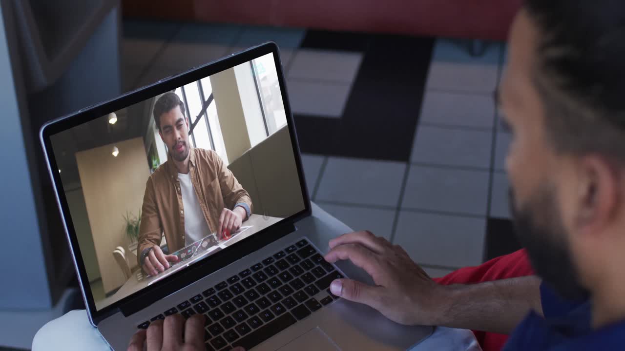 hombre de negocios afroamericano usando una computadora portátil haciendo una videollamada con un colega