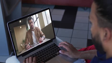 Afroamerikanischer-Geschäftsmann,-Der-Einen-Laptop-Nutzt-Und-Einen-Videoanruf-Mit-Einem-Männlichen-Kollegen-Führt