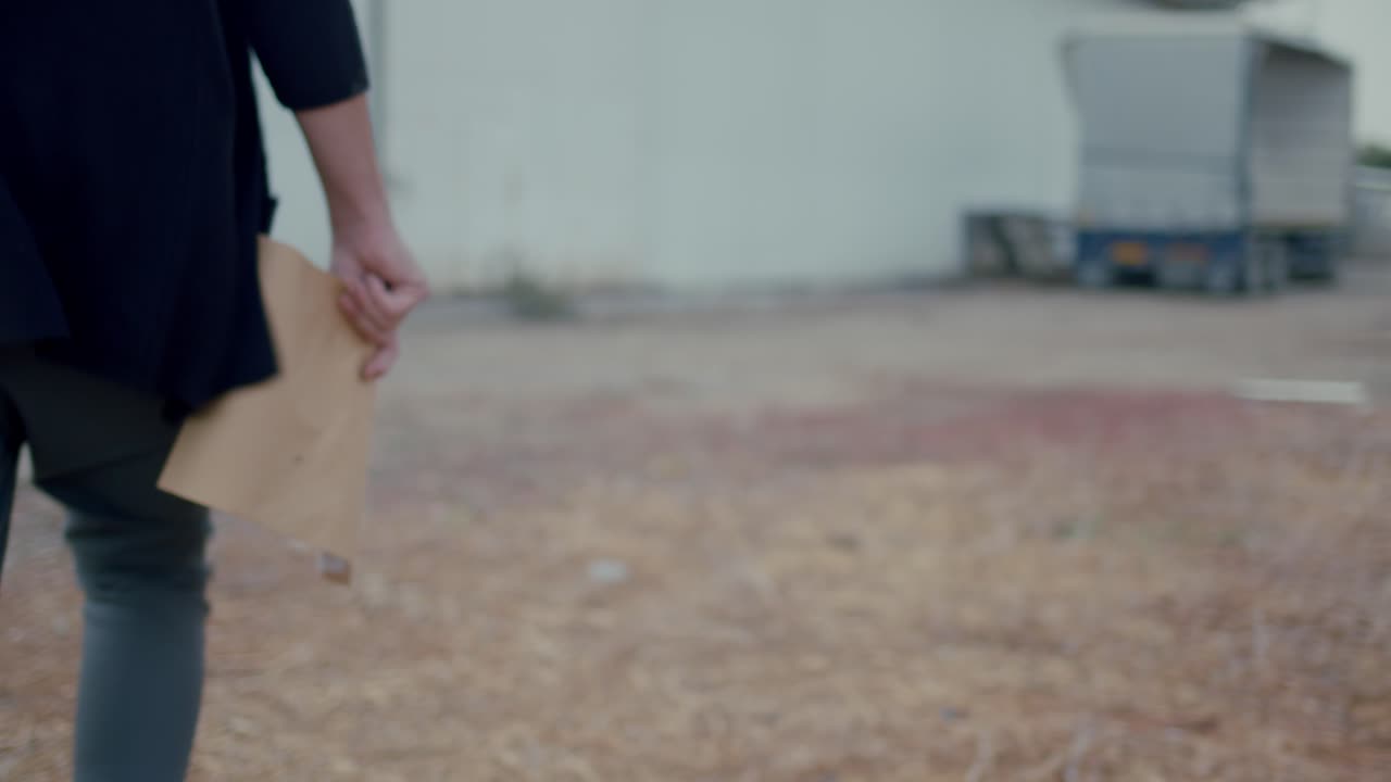 봉투를 들고 창고를 향해 걸어가는 남자