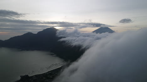 Nubes-Blancas-Moviéndose-Sobre-Las-Siluetas-Del-Monte-Batur-Durante-El-Amanecer