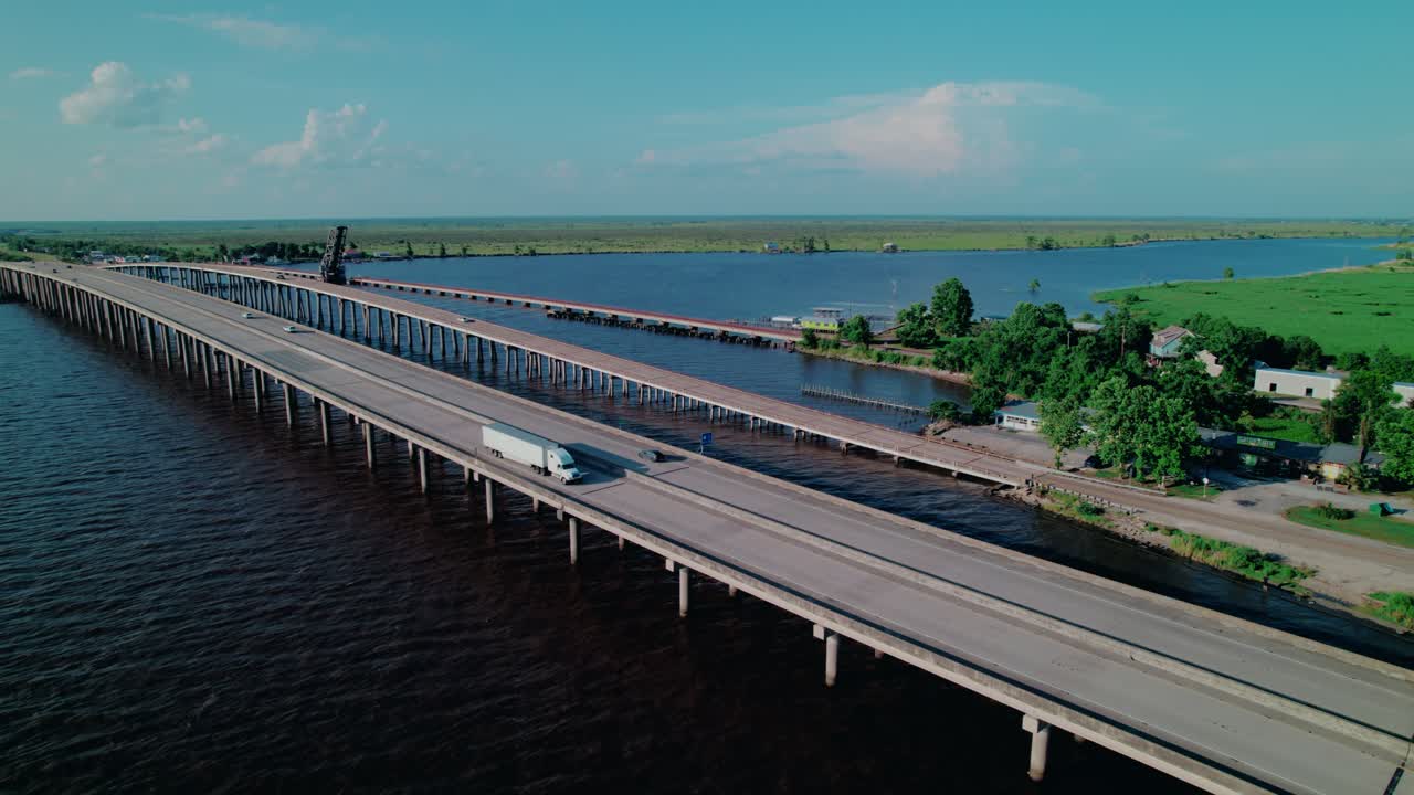 Aerial flyover of a dry van semi truck crossing the Manchac Swamp Bridge near Ponchatoula, LA—ideal for transport and infrastructure B-roll.
