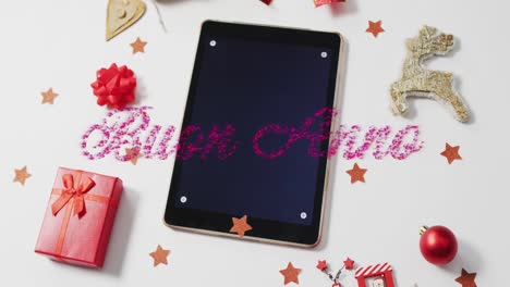animación del texto de buen anno sobre decoraciones navideñas y tableta