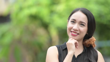 young beautiful asian businesswoman thinking in the streets outdoors