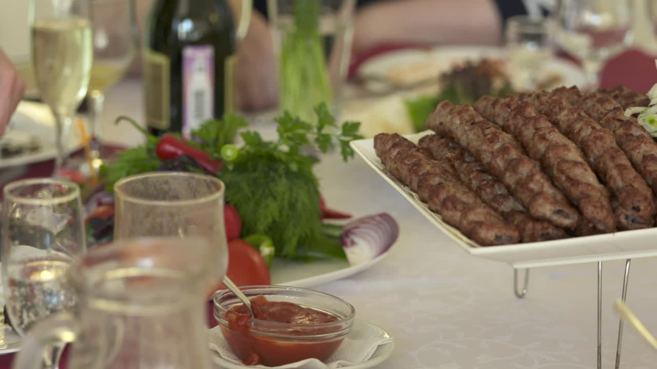 mesa de cena servida con kebabs lula y verduras frescas