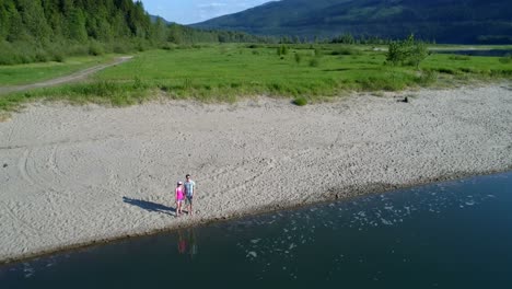 couple standing together on lakeshore 4k