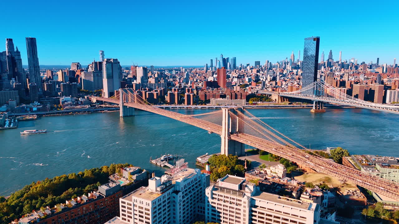 New York, USA, 8 ottobre 2025: Imbarcazioni si muovono lungo il paesaggio acquatico dell'East River sotto il Manhattan Bridge e il Brooklyn Bridge. Vista del centro di New York dal lato di Brooklyn. Prospettiva aerea