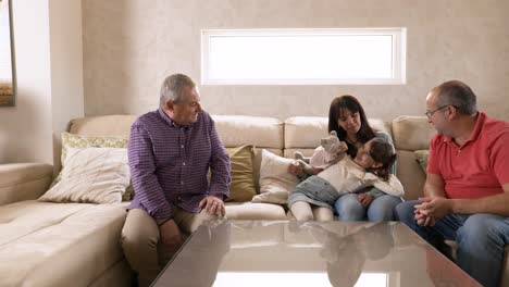 gay couple on the sofa with their daughter and granddaughter playing