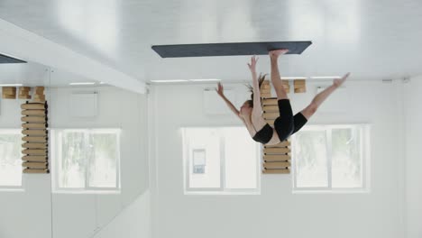 woman practicing handstand yoga pose in a gym studio