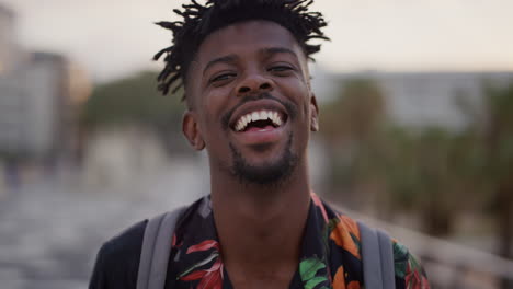 portrait happy african american man laughing cheerful attractive black tourist enjoying summer vacation travel looking relaxed funky hairstyle slow motion