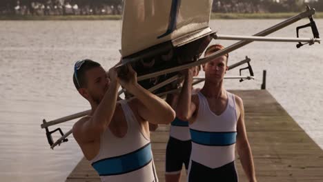 el equipo de remadores masculinos poniendo el barco en sus hombros