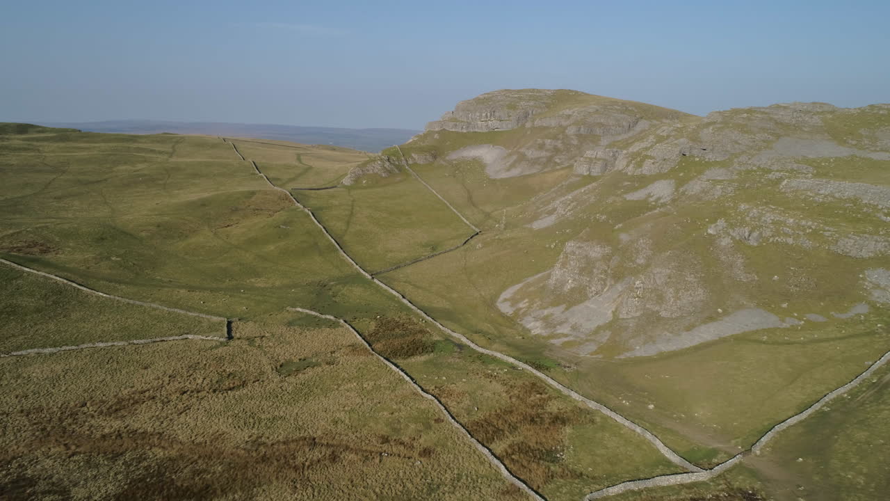 toma aérea de drones de warrendale nudos yorkshire dales campo hierba y colinas rocosas con ovejas de granja y paredes de piedra seca en el soleado día de verano reino unido