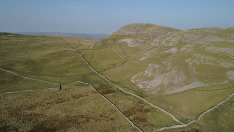 aerial drone shot of warrendale knots yorkshire dales countryside grass and rocky hills with farm sheep and dry stone walls on sunny summer day uk