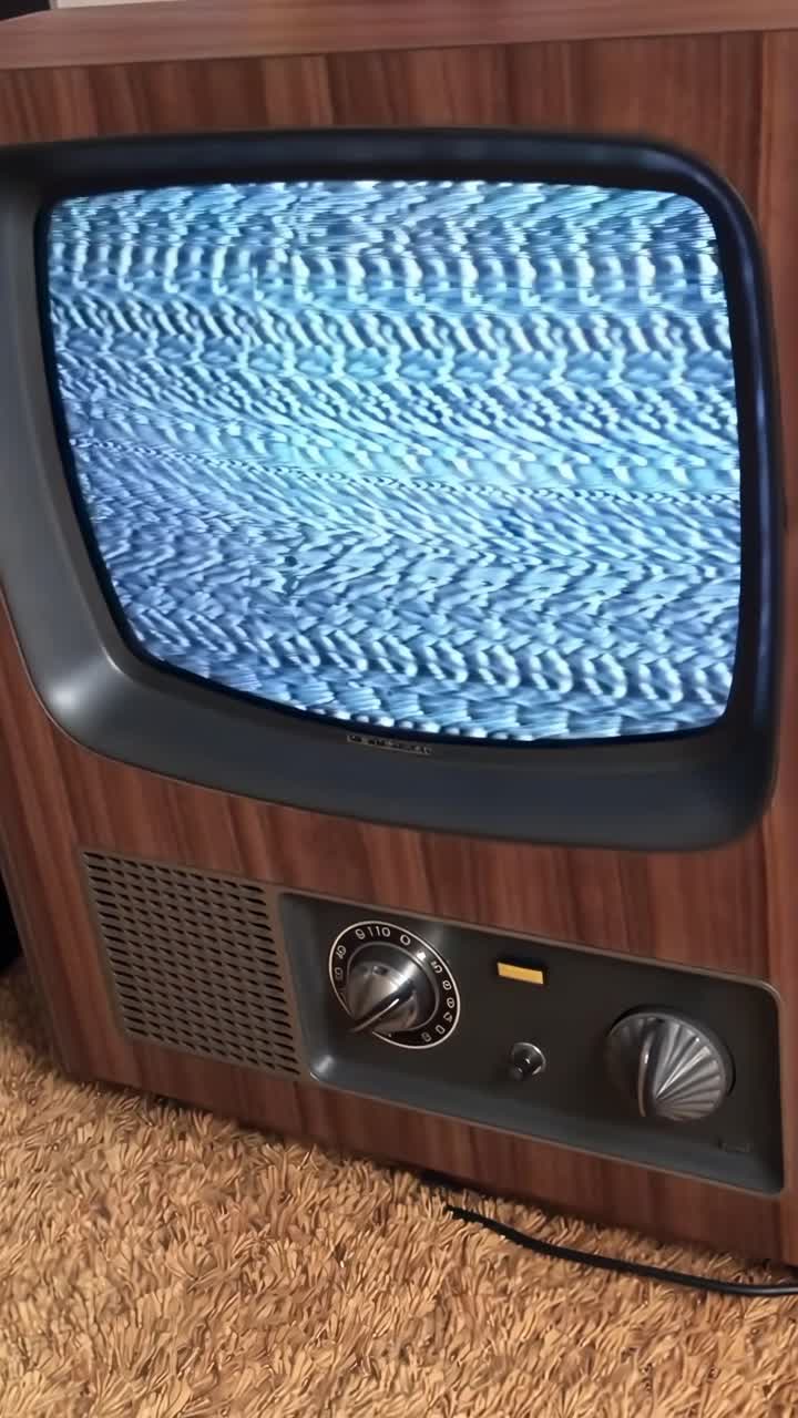 TV vintage con rumore statico, angolata leggermente dall'alto, evoca nostalgia dei video retrò