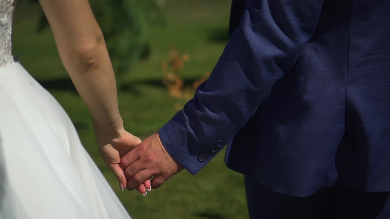 las novias caminan en el parque tomadas de la mano.