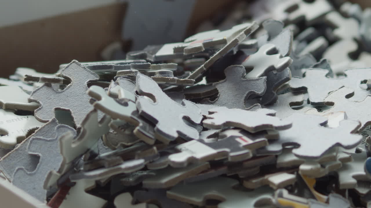 piezas de rompecabezas vertidas en una caja y barajadas, macro