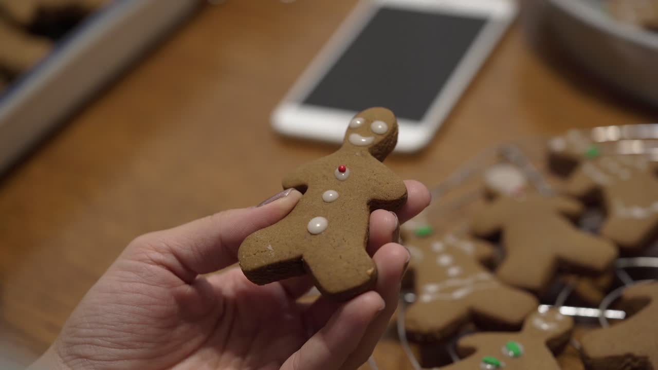 Close-up shot of a lady putting icing on a gingerbread man