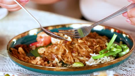 savoring delicious shrimp pad thai with chopsticks