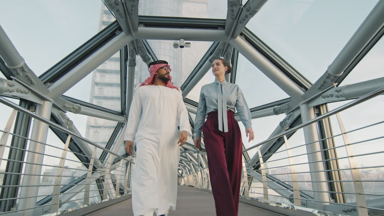 Diverse Business Couple Walking Along Glass Bridge