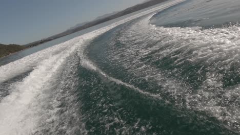 spectral highlights on boat wake making dizzy tight turns in lagoon