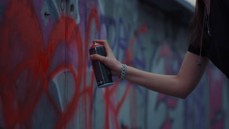 chica dibujando un corazón rojo en el edificio