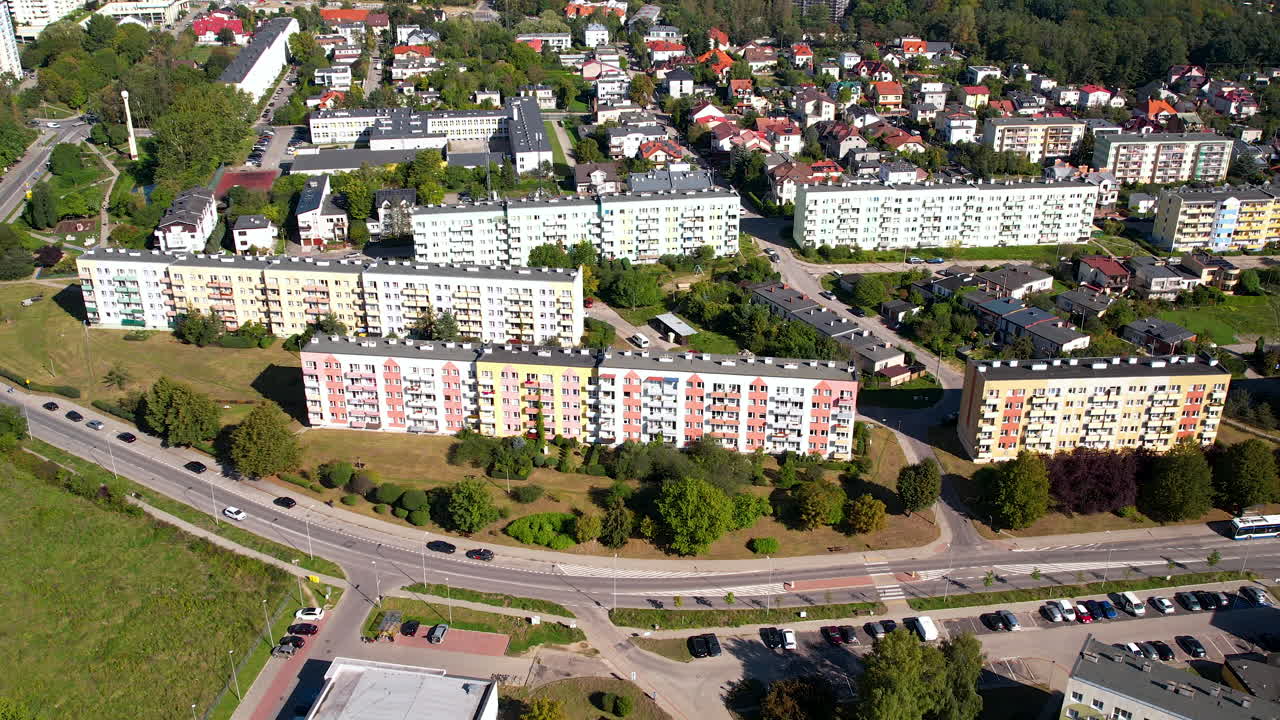 Förortslägenheter och hus kantar en gräsbevuxen sluttning i Polen.