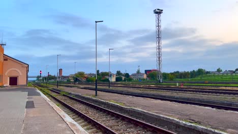 Paisaje-Industrial-Con-Torre-De-Luz,-Vías-De-Tren-Y-Una-Plataforma-Temprano-En-La-Mañana