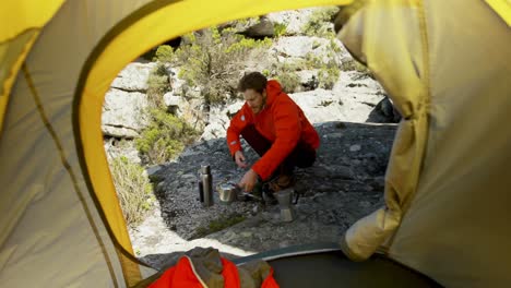 male hiker preparing coffee in countryside 4k