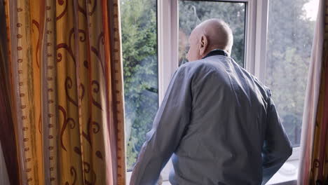 elderly man looking out window