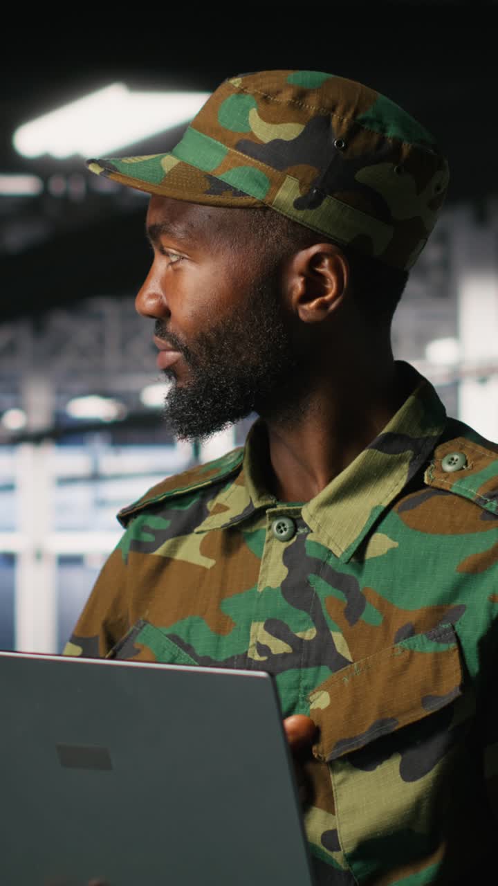 Vertical video Army IT specialist in data center uses laptop to defend networks against threats
