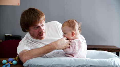 Positive-excited-dad-playing-with-baby-daughter