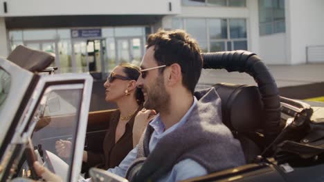couple enjoying a drive in a vintage convertible at the airport