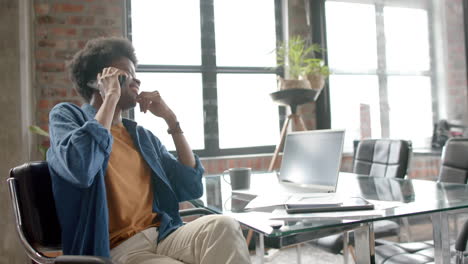 happy african american casual businessman talking on smartphone at home, copy space, slow motion