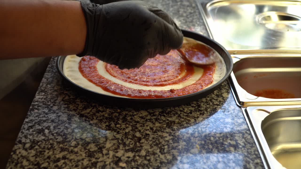 피자 반죽에 토마토 소스를 첨가하는 것