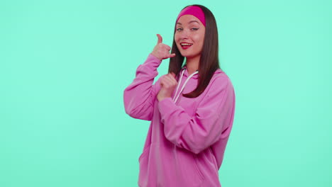 Teenager-girl-in-pink-hoodie-looking-at-camera-doing-phone-gesture-like-says-hey-you-call-me-back