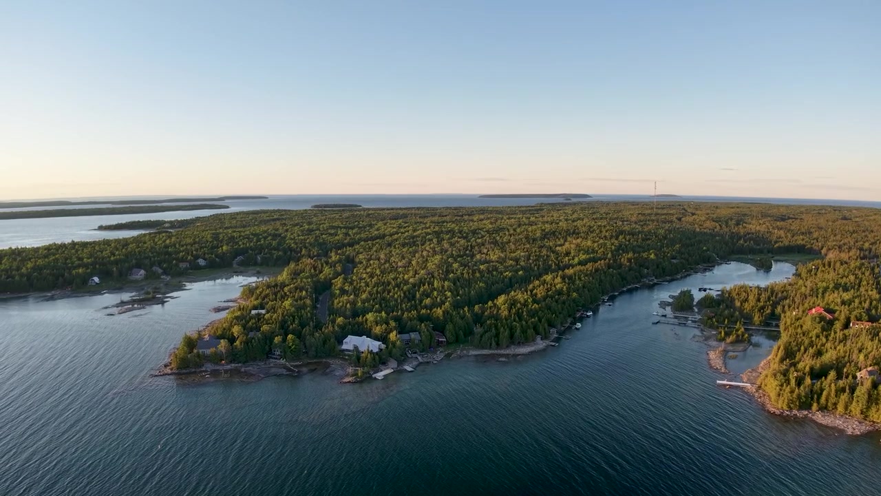 Une vaste étendue d'eau bleue du lac entoure des péninsules boisées dans la nature sauvage et reculée de Tobermory