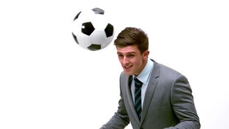 young businessman heading football away
