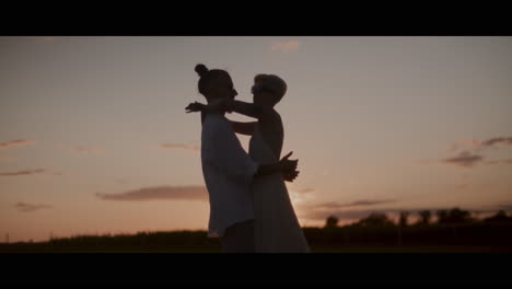 una pareja bailando al atardecer.